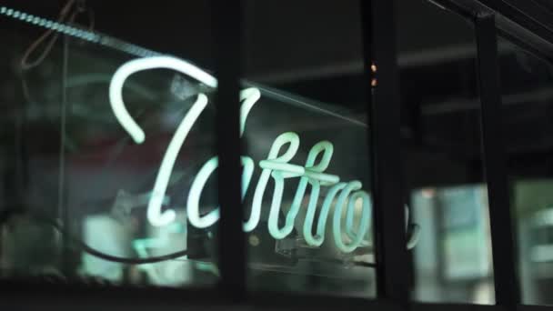 Segno di luce blu tatuaggio su una finestra da un negozio di barbiere e Tattoo Studio — Video Stock