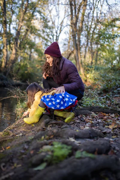 Vorsichtige Mutter und Tochter erkunden Flussnähe im Wald — Stockfoto