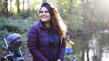 Ormanda bir nehrin kenarında gülümseyen güzel bir kadının üzerindeki güneş ışığı.