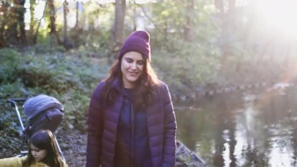 Promień słońca nad piękną kobietą uśmiechającą się i zapraszającą nad rzekę w lesie — Wideo stockowe