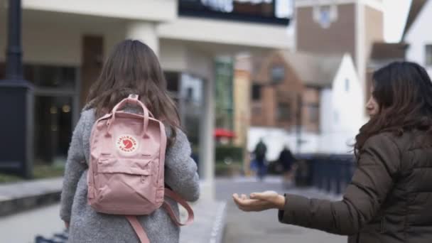 Menina com uma mochila rosa caminhando cuidadosamente ao lado de sua mãe — Vídeo de Stock