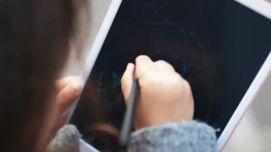 Tablete resim çizen mutlu küçük kıza yaklaş.