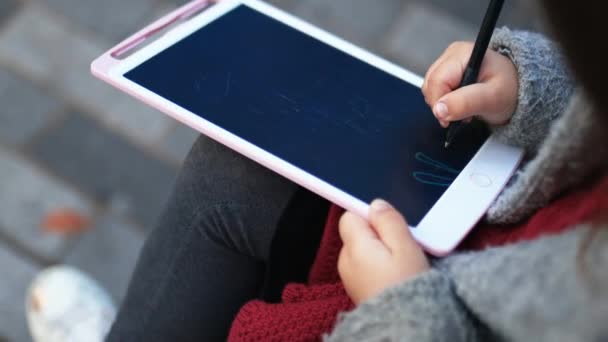 Niña concentrada dibujando figuras de palo en una tableta — Vídeos de Stock