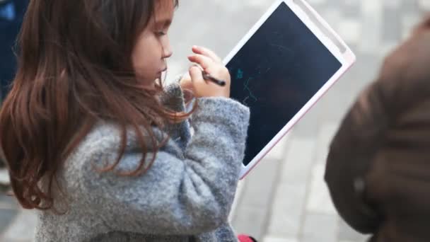 Skoncentrowana dziewczynka rysująca figurki patyka na tablecie — Wideo stockowe