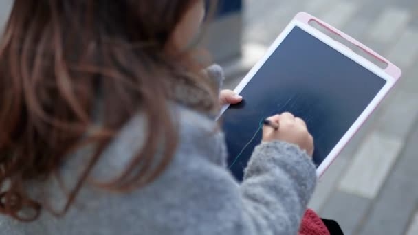 Geconcentreerd meisje tekening stok figuren op een tablet — Stockvideo