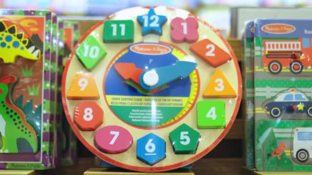 Bebek oyuncaklarıyla dolu rafta renkli figürlü oyuncak saat. — Stok video