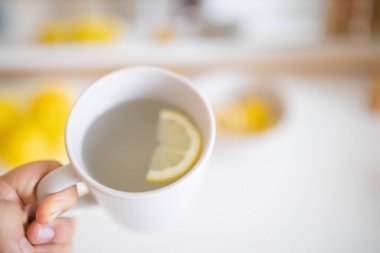 İçinde limon dilimi olan bir bardak limonlu çay.