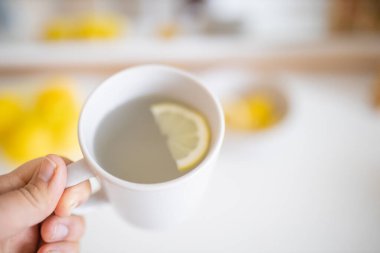 İçinde limon dilimi olan bir bardak limonlu çay.