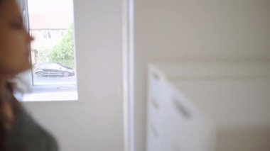 Sabırsız kadın beyaz bir çekmecenin önünde duruyor.