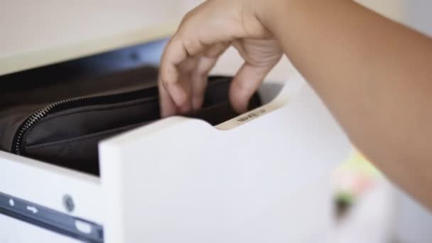 Mujer tranquilamente tomando la bolsa cosmética gris dentro de un cajón blanco — Vídeos de Stock