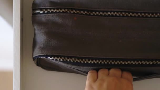 Female hand calmly taking a gray cosmetic bag from a white drawer — Stock Video