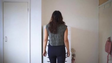 Güzel bir kadın beyaz çekmecelere doğru yürüyor.