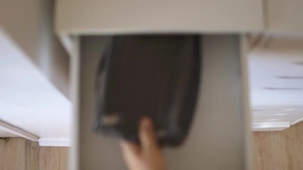 Female hand calmly putting cosmetic bag inside a drawer and closing it — Stock Video