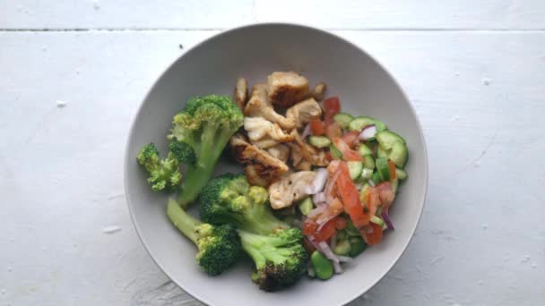 Vidlička sbírá sekanou zeleninu z brokolice a kuřecího salátu — Stock video