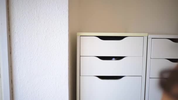 Female hand calmly opening a white drawer with a gray cosmetic bag inside — Stock Video