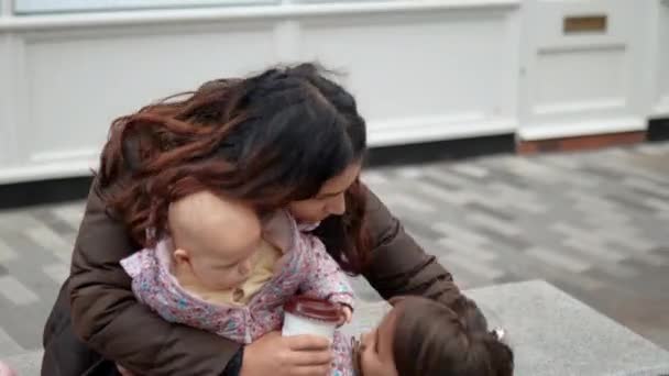 Ευτυχισμένη μητέρα χαμογελά και αγκαλιάζει τις δύο ευτυχισμένες και αξιολάτρευτες κόρες της — Αρχείο Βίντεο