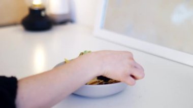 Guacamole ve fasulyelerle kaplı nacho toplayan bir kadın.
