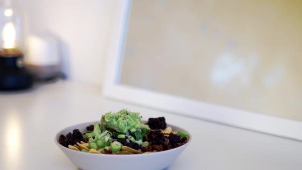 Vit skål med nachos täckt med guacamole och svarta bönor — Stockvideo