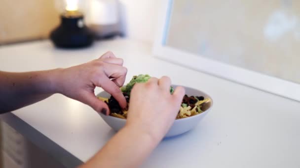 Nachos de cueillette à la main pour femmes recouverts de guacamole et de haricots — Video