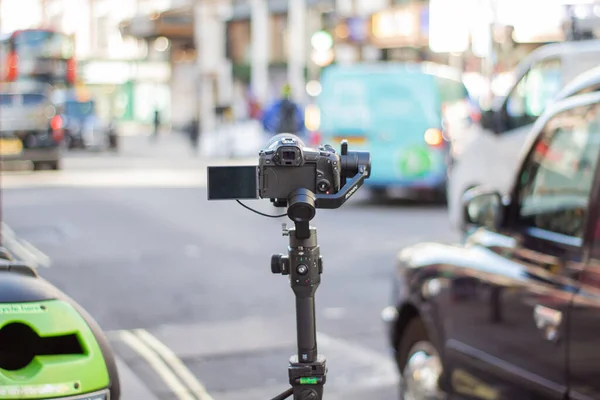 Bulanık trafiği ve sokaktaki insanları kaydeden tripoddaki kamera.