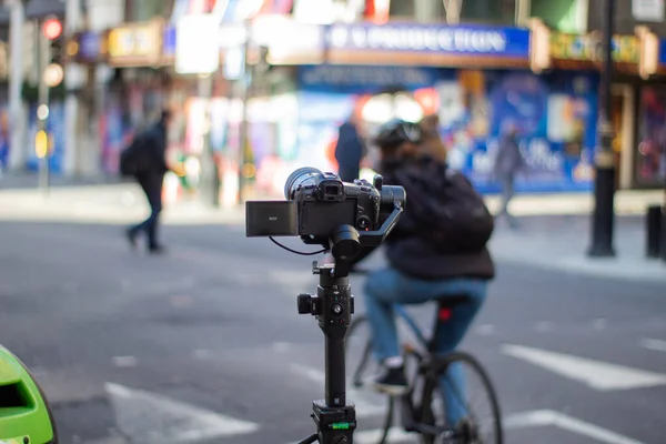 Câmera no tripé gravando tráfego desfocado e pessoas na rua — Fotografia de Stock