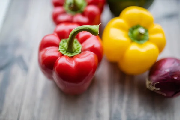 Rode en gele paprika 's op een houten tafel — Stockfoto