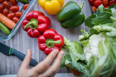 Taze ve renkli dolmalık biber ve diğer sebzeler ahşap masada.