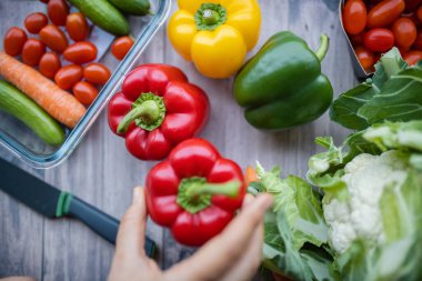 Taze ve renkli dolmalık biber ve diğer sebzeler ahşap masada.