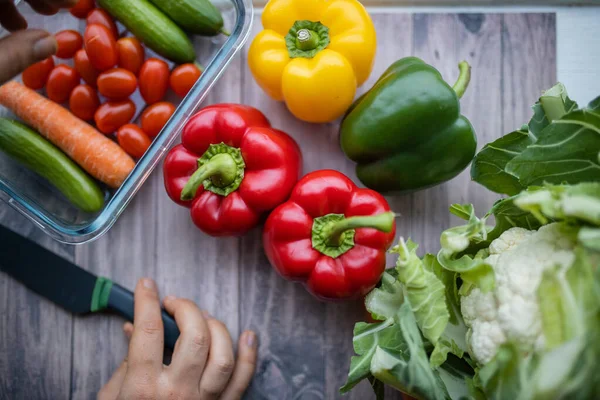 Fresh and colorful bell peppers and other vegetables on wooden table