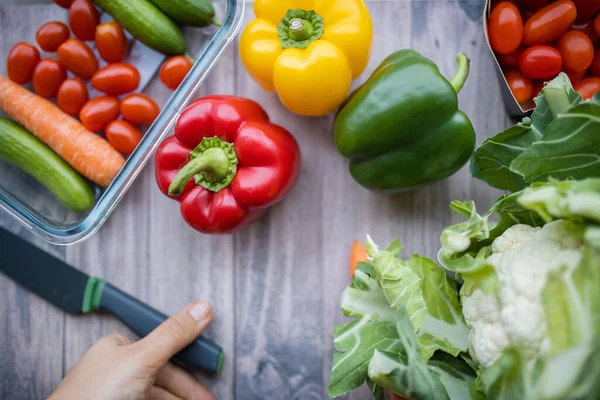 Fresh and colorful bell peppers and other vegetables on wooden table