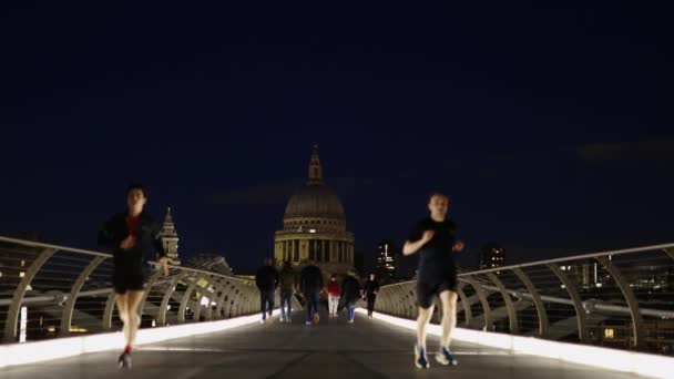 Собор Святого Павла С моста Тысячелетия ночью с людьми бег трусцой — стоковое видео