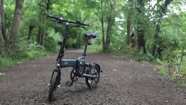 Fiido Ηλεκτρικό ποδήλατο στη μέση ενός χωματόδρομου σε ένα πάρκο — Αρχείο Βίντεο
