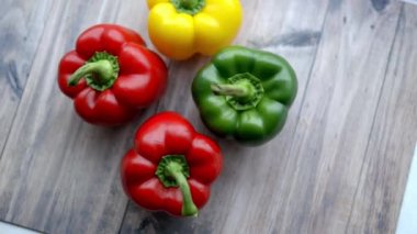 Ahşap bir masadan yeşil bir dolma biber alan bir kadın.