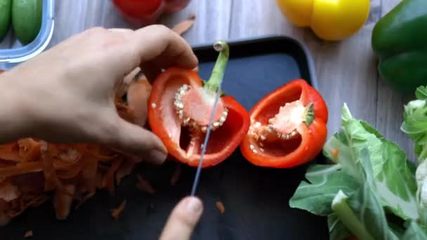 Ženské ruce pevně krájí červenou papričku na podnose — Stock video