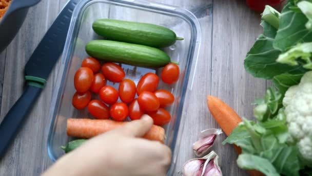 女性の手は野菜とプラスチック容器からニンジンを選ぶ — ストック動画
