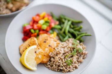 Yeşil fasulye ve domatesli somon ve karabuğday yemeği.