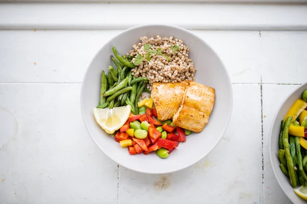 Yeşil fasulye ve domatesli somon ve karabuğday yemeği.