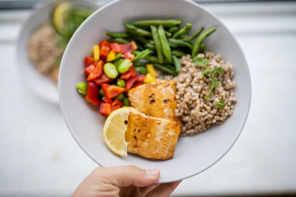 Yeşil fasulye ve domatesli somon ve karabuğday yemeği.