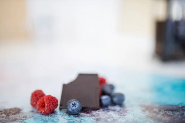 Bijten chocoladereep en bessen op een kleurrijke placemat — Stockfoto