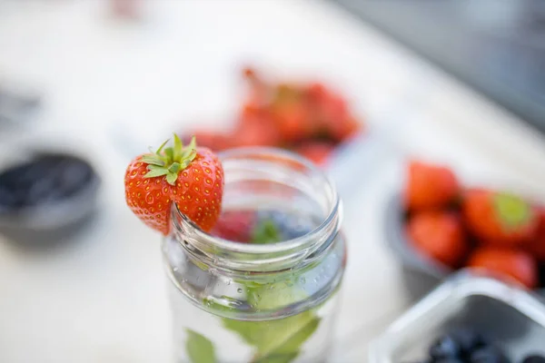 Aardbei aan de rand van een munt en bessen drinken — Stockfoto