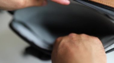 Erkek elleri gri bir sırt çantasının boş arka bölümünü gösteriyor.