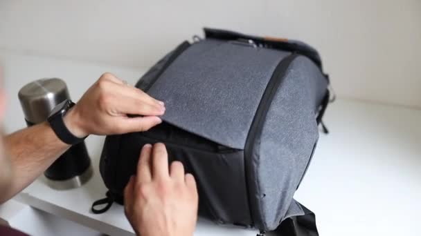 Męska ręka pokazująca dolne paski szarego plecaka — Wideo stockowe