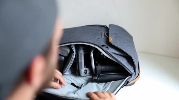 Hombre mostrando los compartimentos laterales de una mochila gris — Vídeos de Stock