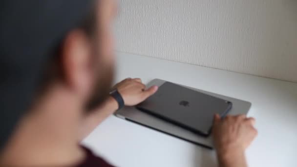 Beyaz masadaki adam gümüş rengi Ipad ve Mac gösteriyor. — Stok video