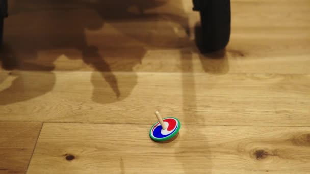 Spinning top speelgoed zachtjes bewegen op de houten vloer — Stockvideo