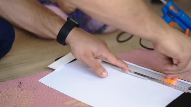 Мужские руки измеряют и режут бумажный лист с гильотиной — стоковое видео