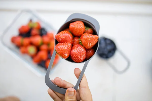 Taza medidora femenina llena de fresas frescas —  Fotos de Stock