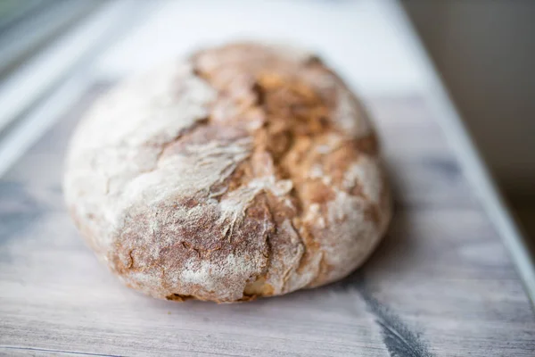 Pão de massa em um balcão de cozinha branco ao lado de uma janela — Fotografia de Stock