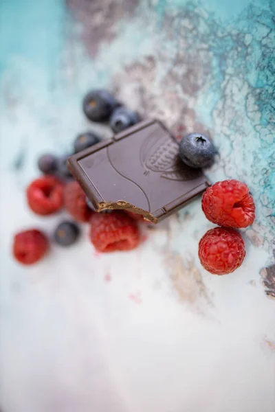 Bijten chocoladereep en bessen op een kleurrijke placemat — Stockfoto