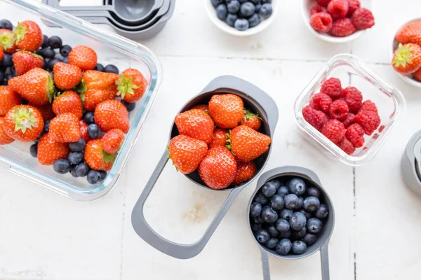 Jordgubbar, blåbär och hallon i plastbehållare ovanifrån — Stockfoto